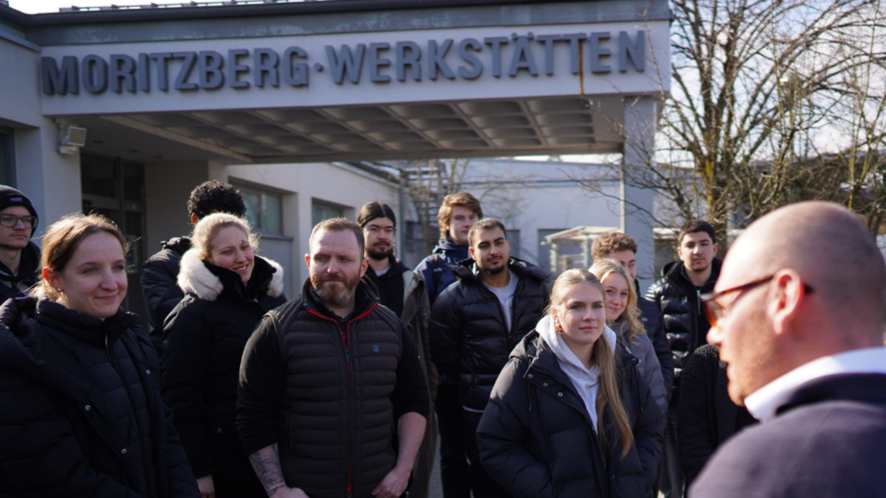 Ein Mitarbeiter der Lebenshilfe im Gespräch mit Auszubindenden von CeramTec