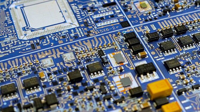 Une carte de circuit imprimé bleue de CeramTec avec des composants passifs.