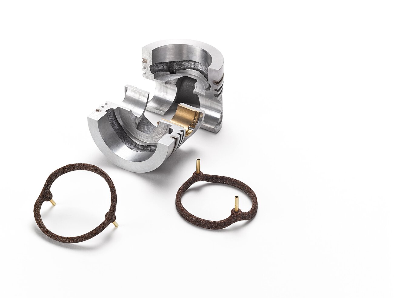 Ein silbernes Metallstück und braune Salzkerne für die Gießereitechnik