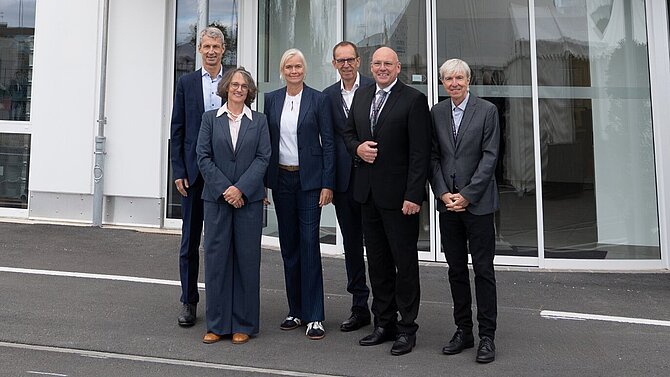 Eric Oellerer, Dr. Carla Kriwet und Horst Garbrecht mit Gästen vor dem Eingang von CeramTec in Marktredwitz