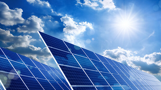 A solar park with the sun in the background