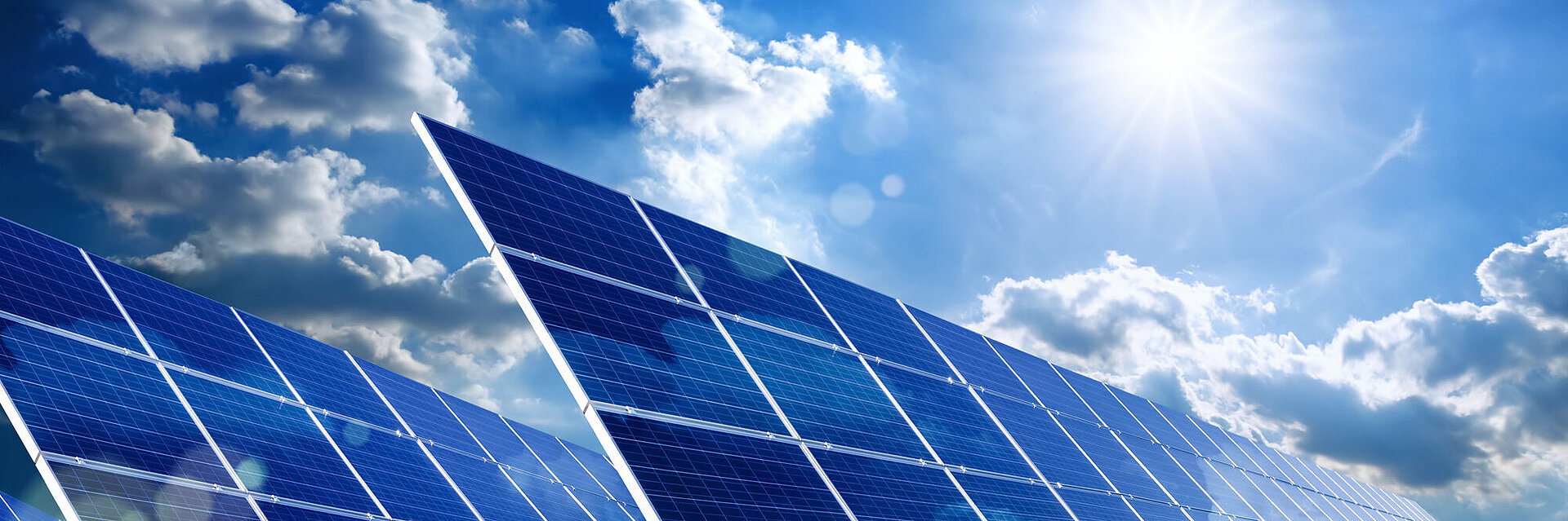 A solar park with the sun in the background