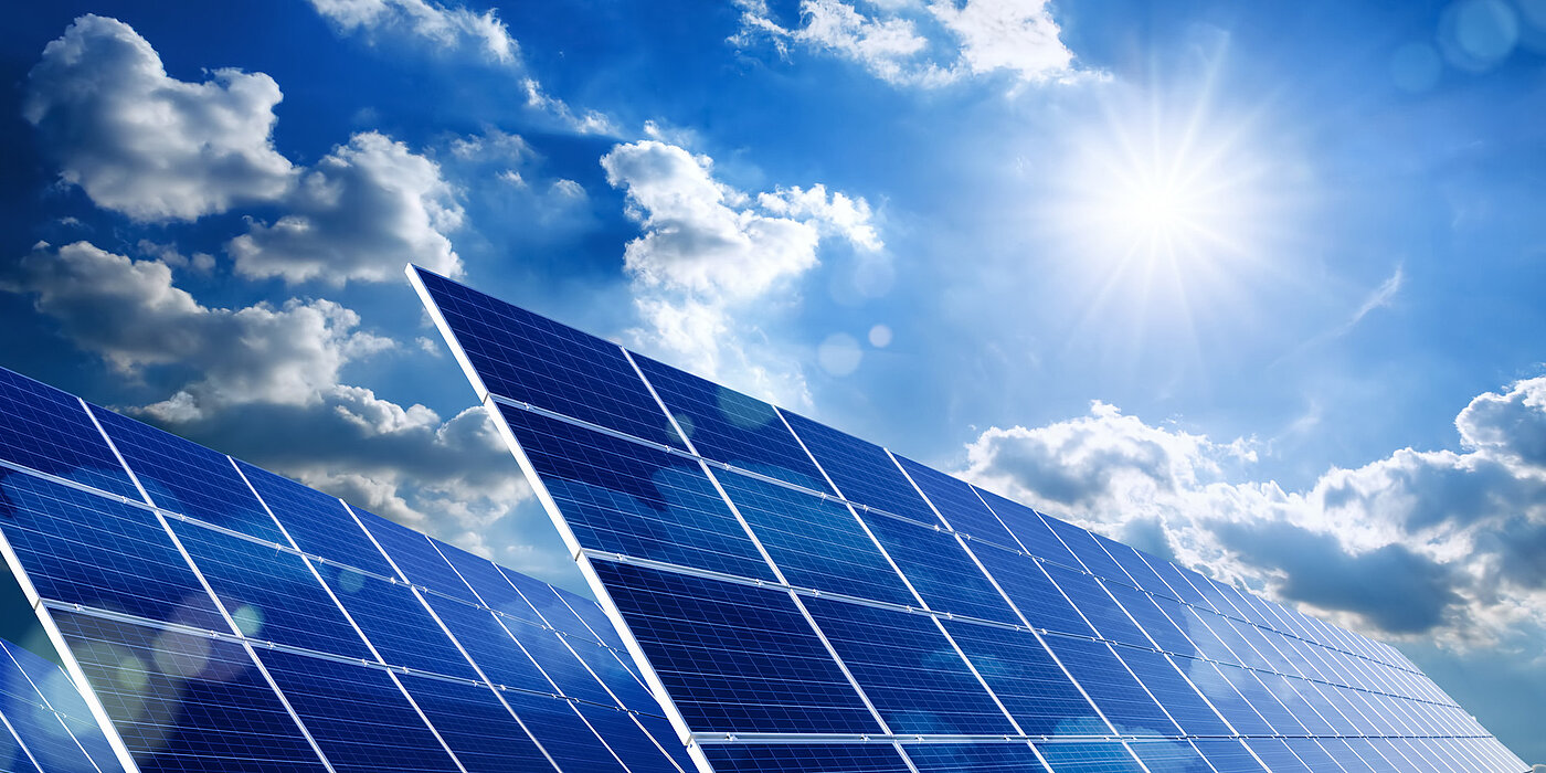 A solar park with the sun in the background