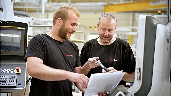 Dva zaměstnanci společnosti CeramTec pracují na stroji ve výrobě