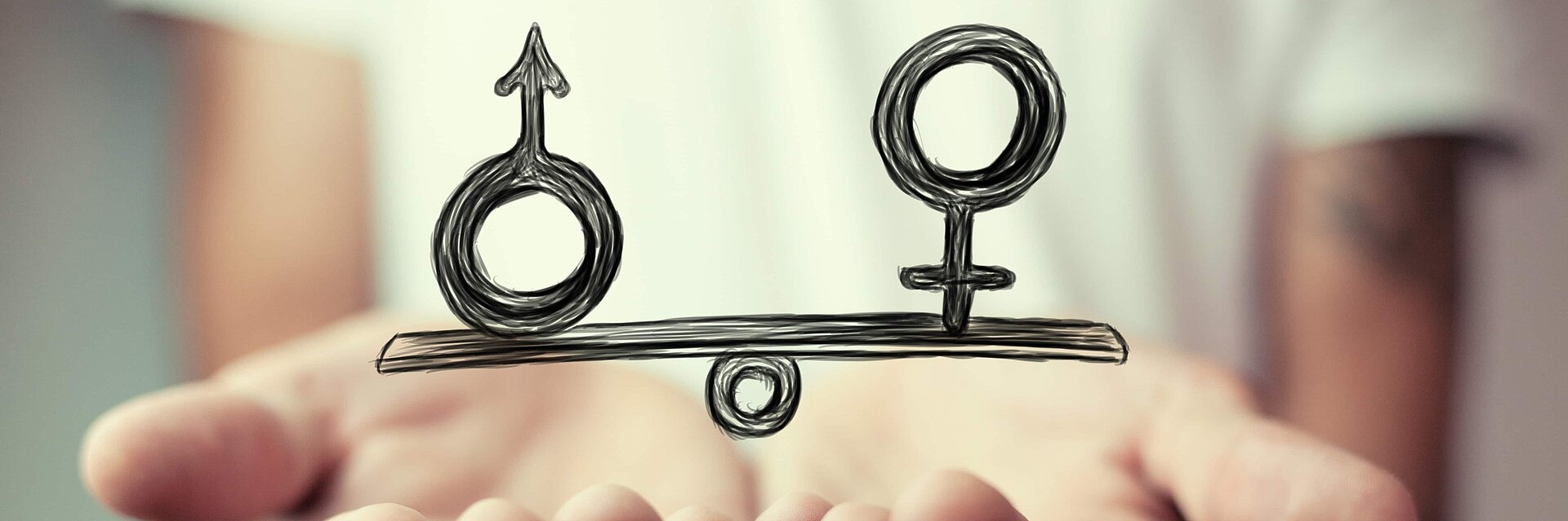 A hand and a scale symbolise the gender pay gap