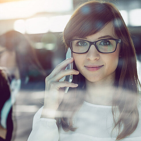Femme souriante en train de parler au téléphone