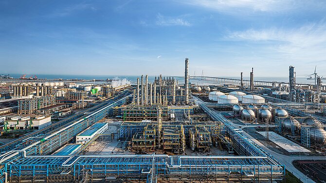 Vue panoramique aérienne d'un immense complexe industriel côtier de raffinage pétrolier et pétrochimique.