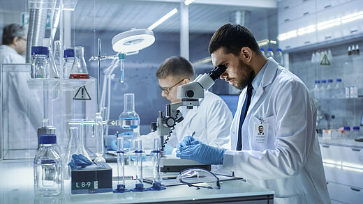 Researchers in the laboratory look through a microscope