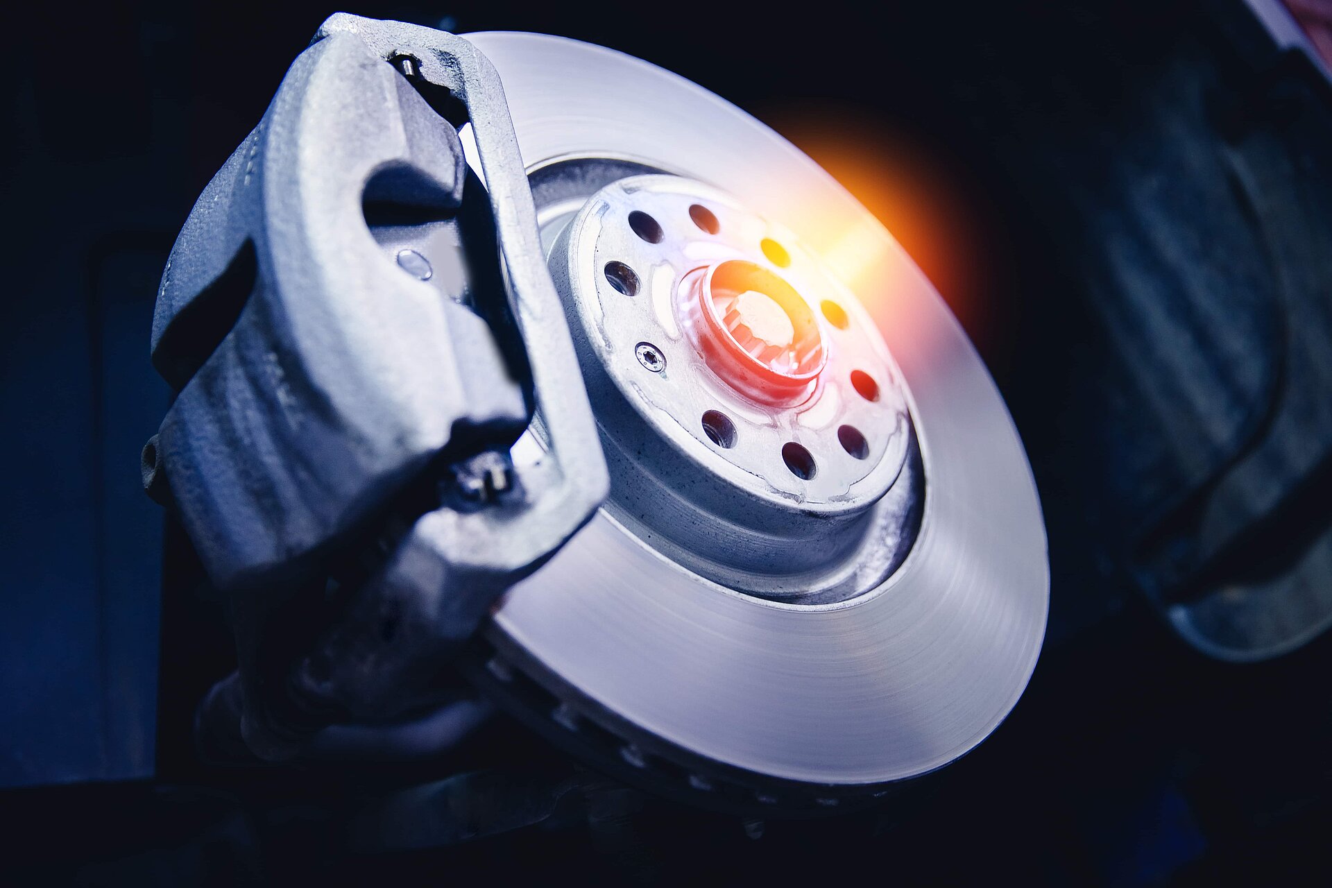 Gros plan sur un disque de frein en acier et détail du moyeu de roue avec la lumière du soleil