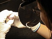 Frau schaut durch eine Lupe auf eine Kugel