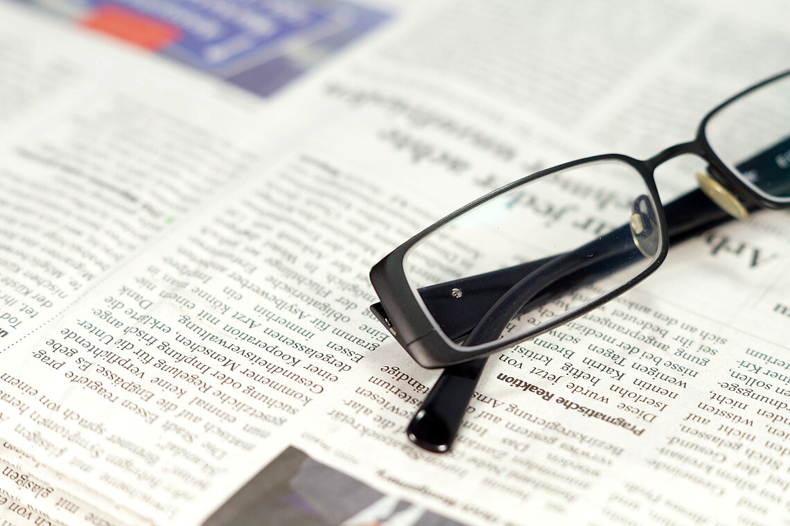Glasses lie on newspapers