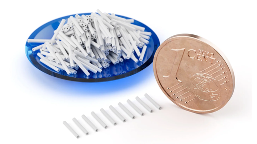 White ceramic tubes next to a 1-cent coin