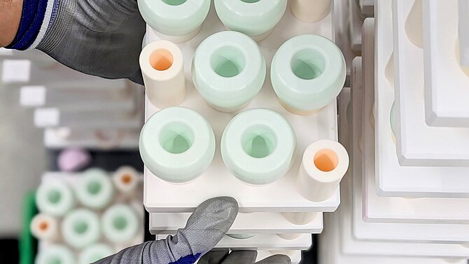 A CeramTec employee processes a series of green ceramic blanks in production