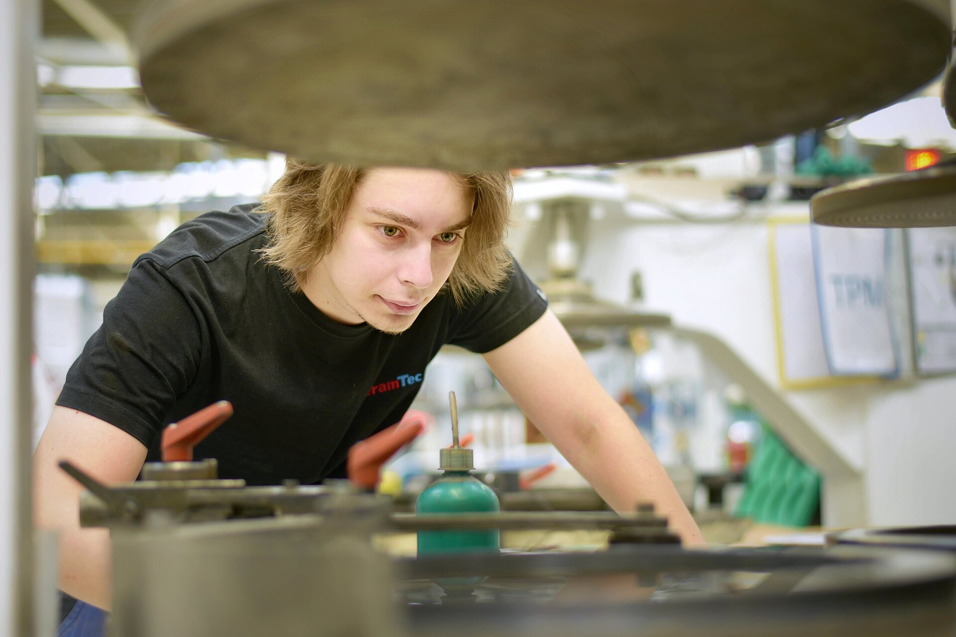 Zaměstnanec společnosti CeramTec se při práci ve výrobě sklání nad strojem