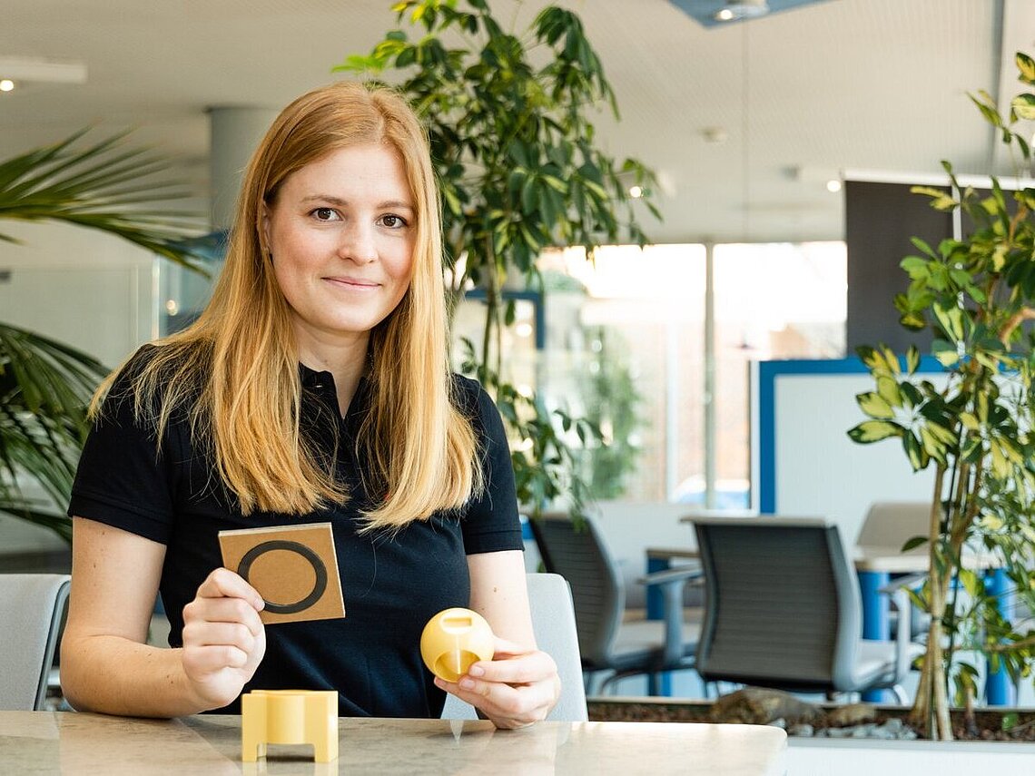 Praktikantin hält Arbeitsstoffe