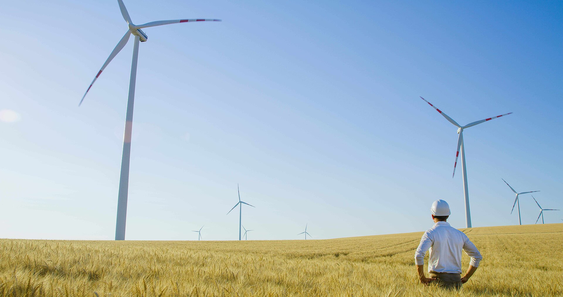 Man standing in front of a wind turbine