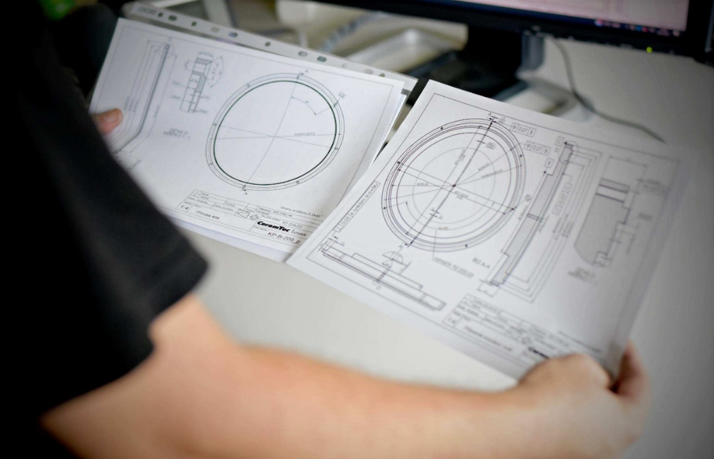 Zaměstnanec CeramTec si prohlíží dva výrobní plány